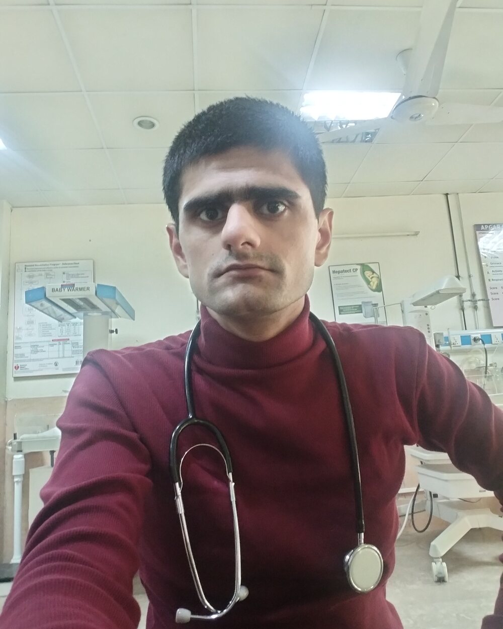 Usman Arshad wearing a stethoscope in a clinical setting
